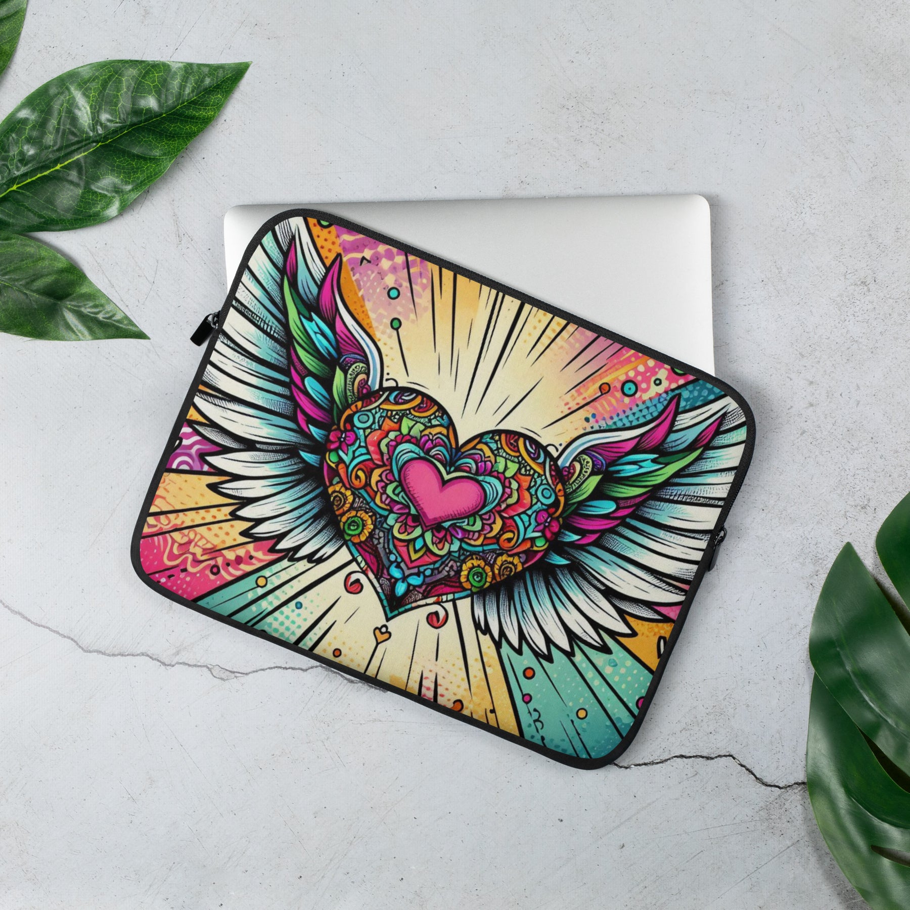 a laptop case with a heart and wings on it